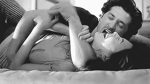 a man and a woman are laying on a bed .