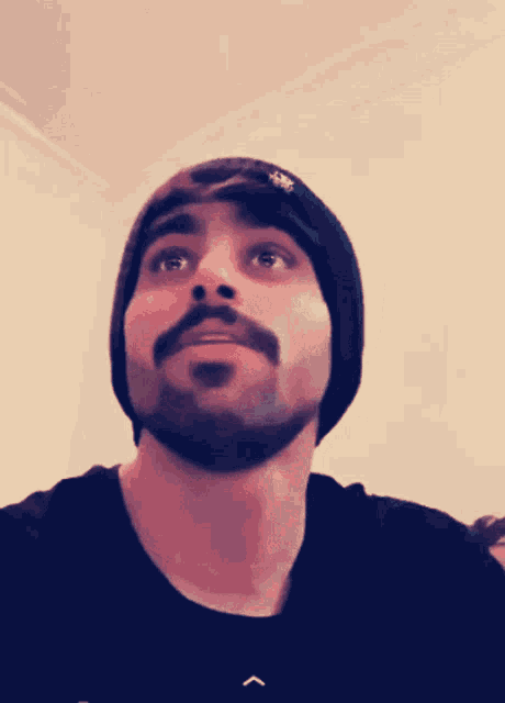a man with a beard wearing a black beanie and a black shirt