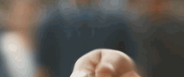 a close up of a person 's fist pointing at something