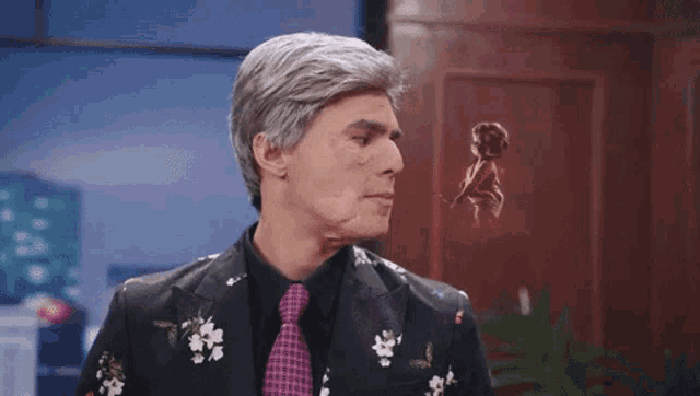 a man in a suit and tie looks at a statue of a woman