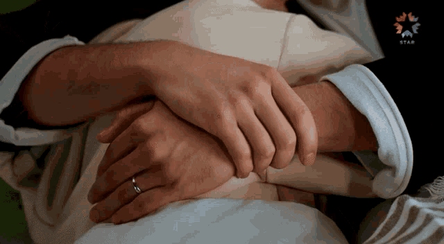 a man and woman are holding hands with a star logo in the background