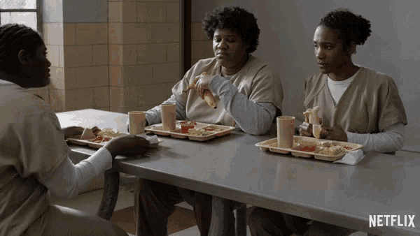 three women are sitting at a table eating food with a netflix logo behind them