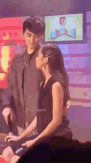 a man and a woman are sitting next to each other on a stage .