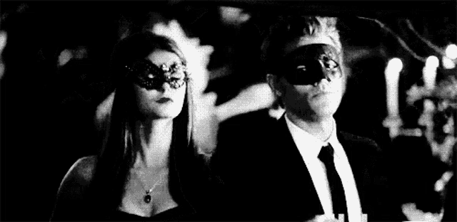 a man and a woman are wearing masks at a party .