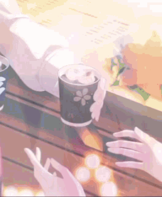 a person holding a cup of coffee with a flower on it