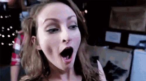 a woman is making a funny face with her mouth wide open .