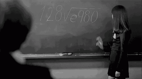 a girl is writing on a blackboard that says 128
