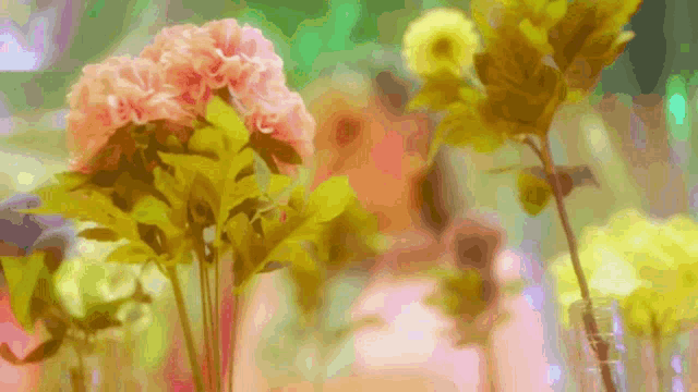 a bunch of pink and yellow flowers in a glass vase