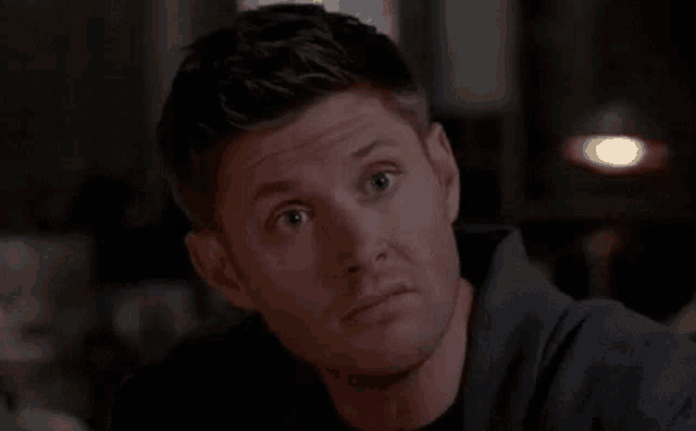 a man is making a funny face while looking at the camera .