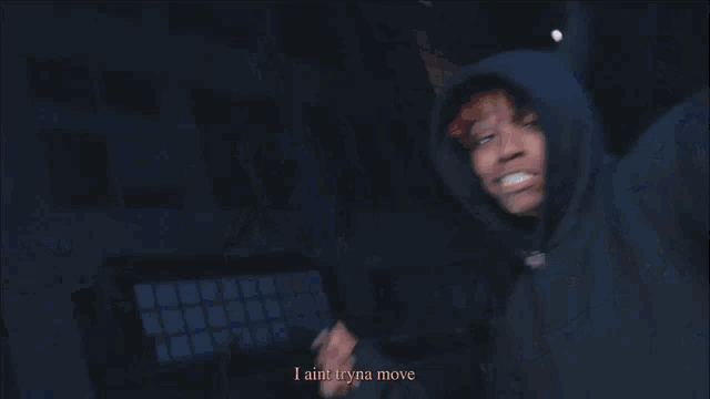 a man in a black hoodie with the words i ain t tryna move above him