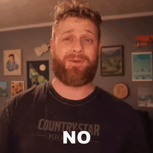 a man with a beard wearing a country star shirt is saying no