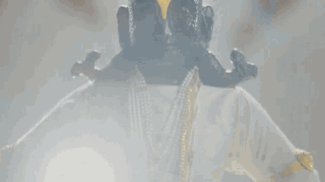 a close up of a statue with a yellow eye and a gold crown