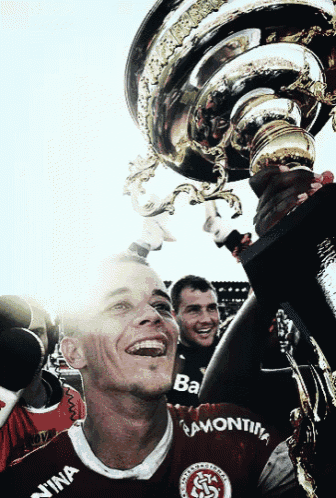 a man holding up a trophy with a shirt that says ba on it