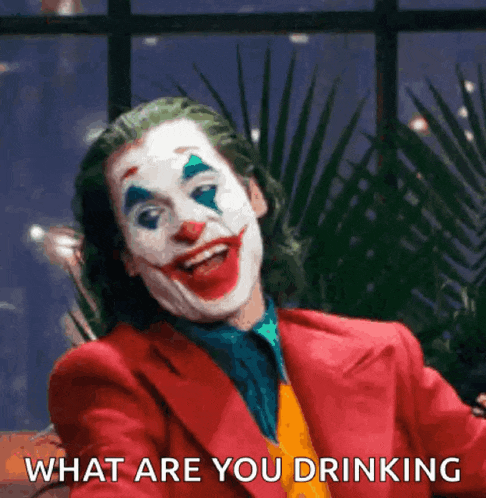 a man dressed as the joker is smiling and asking what are you drinking .