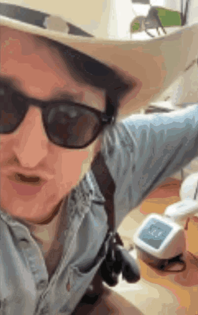 a man wearing a cowboy hat and sunglasses makes a funny face