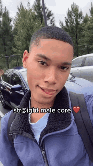 a young man in a blue jacket is taking a selfie with a car in the background and says straight male core on the bottom