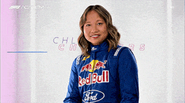 a woman wearing a blue red bull jacket is smiling