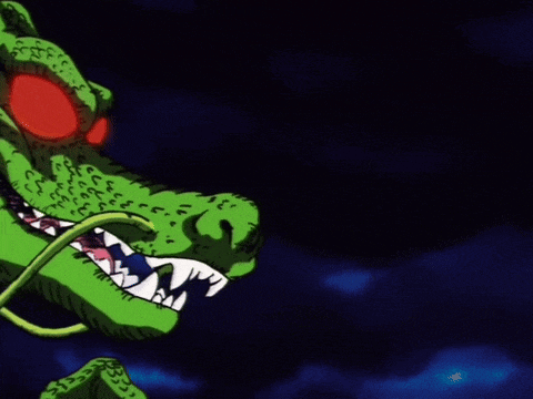 a close up of a green dragon with red eyes and teeth