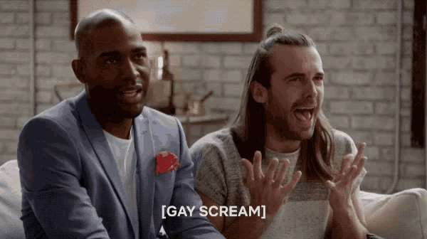 two men are sitting on a couch and one of them is saying " gay scream "