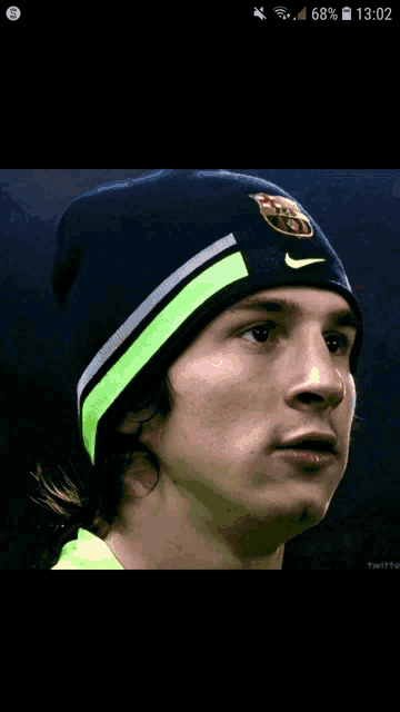 a close up of a man wearing a beanie with a fcb logo on it