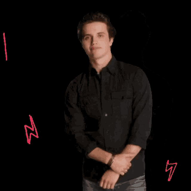 a man in a black shirt makes a rock on sign
