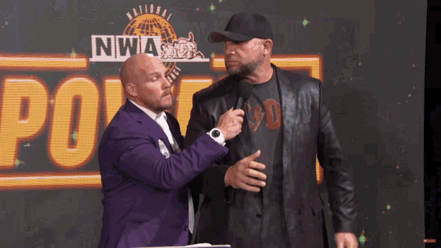 two men are standing in front of a screen that says nwia