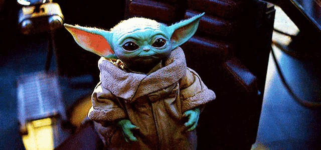 the baby yoda from star wars is sitting in a chair .