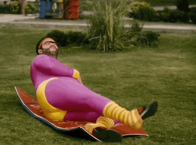 a man in a purple suit is laying on a yoga mat