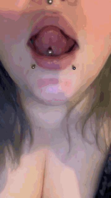 a close up of a woman 's mouth with a piercing in it