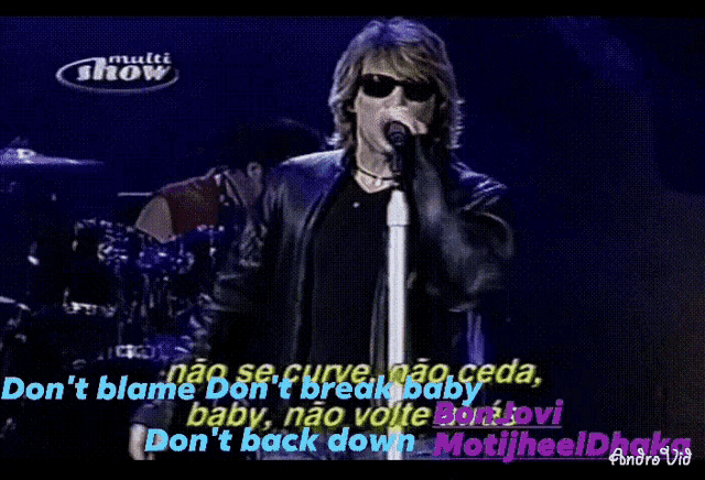 a man singing into a microphone with the words multi show behind him