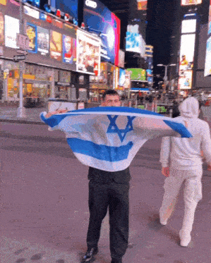 a man in a suit is holding a blue and white flag with the star of david on it