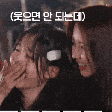 two girls are laughing and one has headphones on