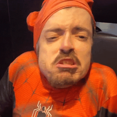 a man in a spider man costume is making a face with his mouth open