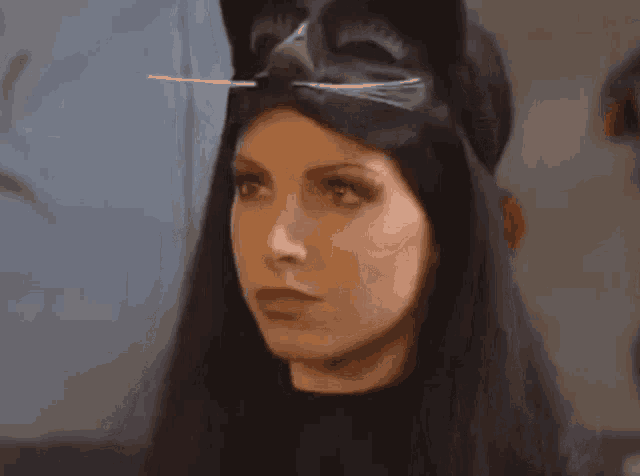 a woman is wearing a cat mask and looking at the camera
