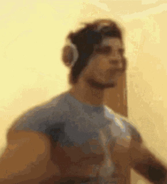 a blurred image of a man wearing headphones and a blue shirt