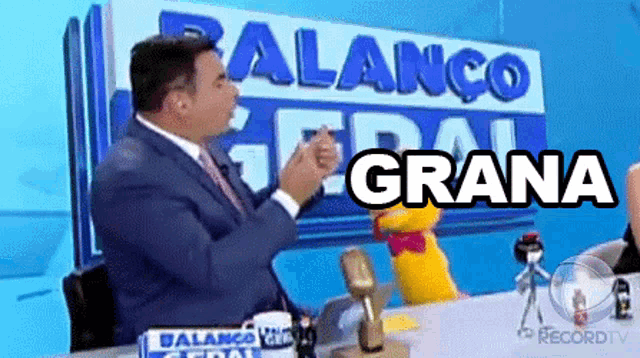 a man sitting at a desk with a sign that says grana