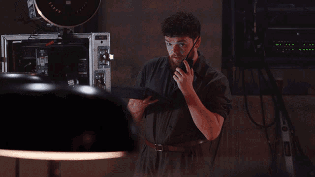 a man is talking on a walkie talkie while holding a clipboard