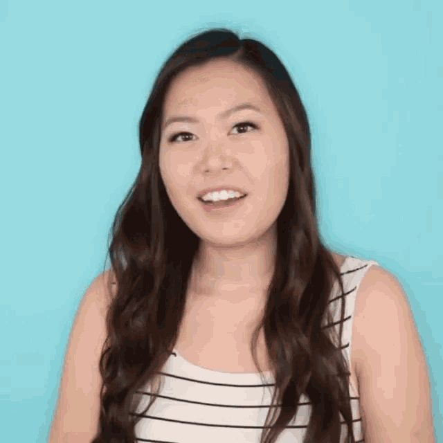 a woman in a striped tank top is making a funny face with her eyes closed