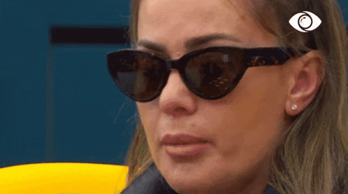 a close up of a woman wearing sunglasses and earrings