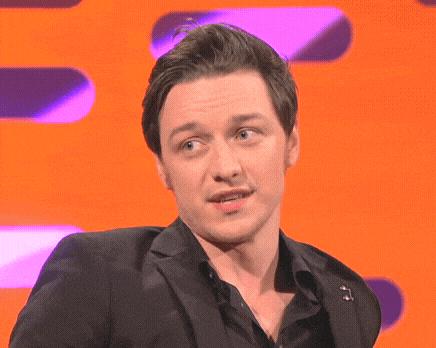 a man in a suit and black shirt is making a face