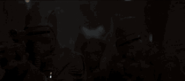a woman with a mask on her face is holding a light saber in her hand .