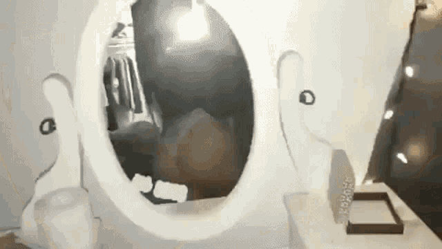 a woman is looking at herself in a mirror in a bathroom .