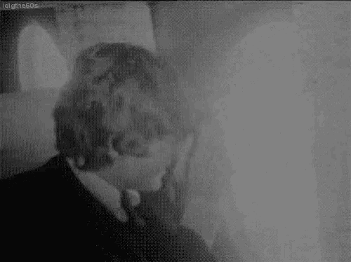 a black and white photo of a man covering his face .