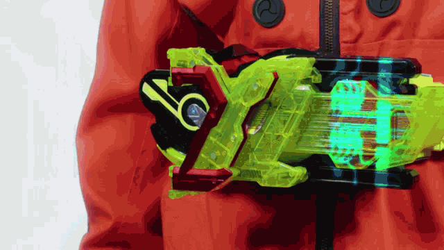 a person in an orange jacket is holding a yellow and red object with the letter y on it