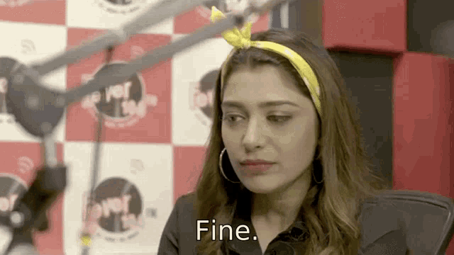 a woman sitting in front of a microphone with the word fine written on her face