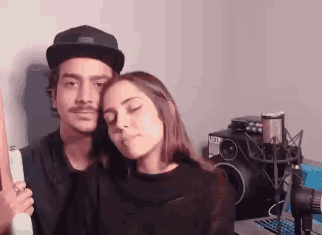 a man and a woman are hugging each other in a room with a microphone .