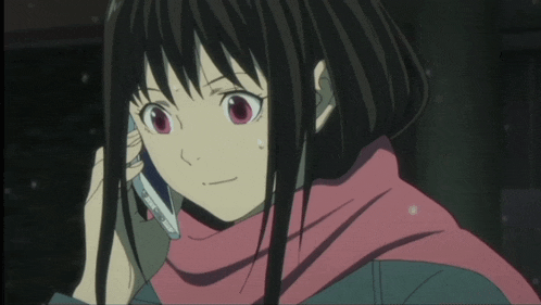 a girl with black hair and red eyes talking on a cell phone
