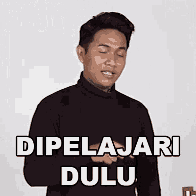 a man wearing a black turtleneck sweater is making a funny face and says dipelajari dulu .
