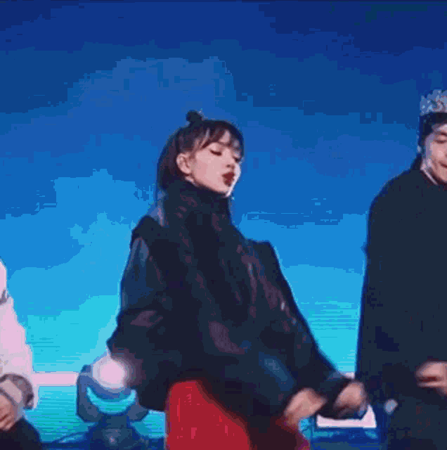 a man and a woman are dancing on a stage in front of a purple background .