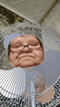 an older woman wearing glasses is being blown by a fan
